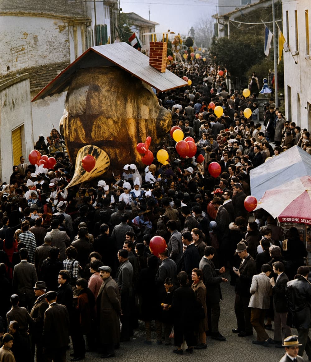 A colour photograph of the crowd filling the village street around an allegorical float, balloons everywhere